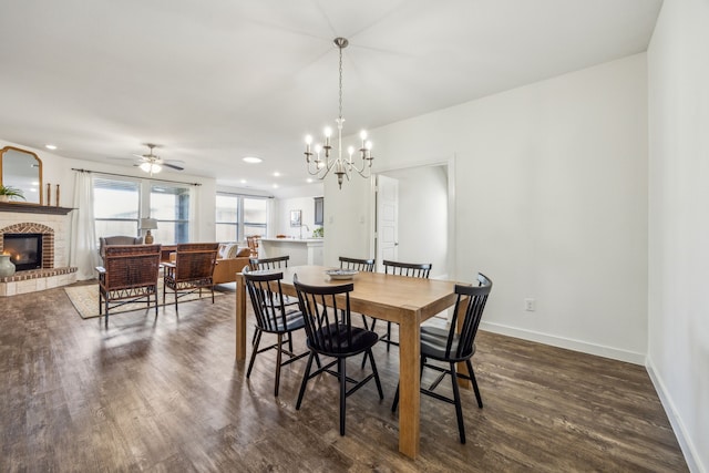 dining area featuring a brick fireplace, dark hardwood / wood-style floors, and ceiling fan