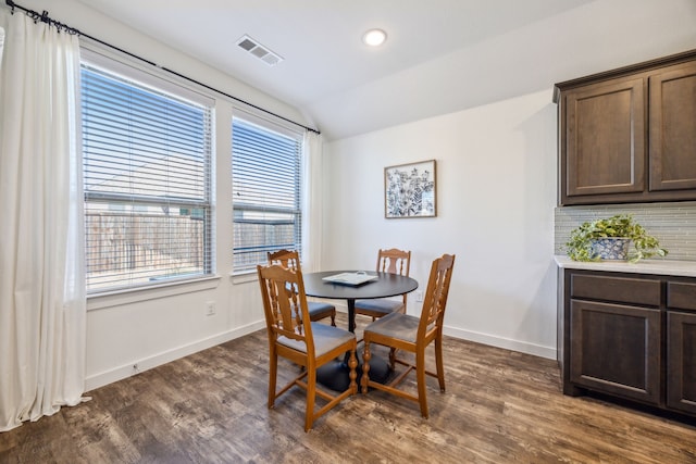 dining space with lofted ceiling and dark hardwood / wood-style floors