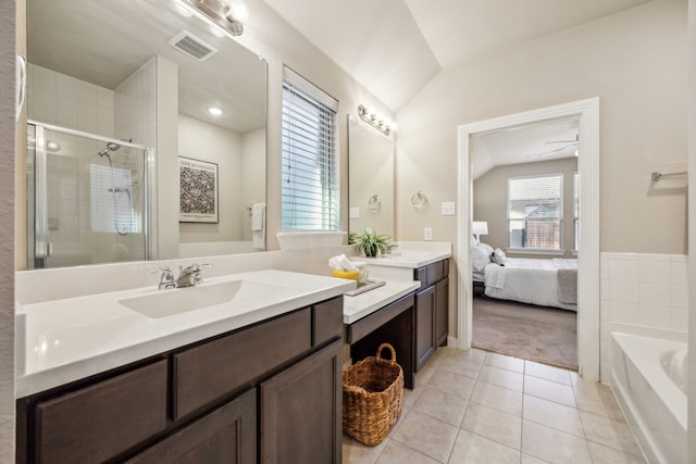 bathroom featuring vanity, lofted ceiling, a bath, and tile patterned floors