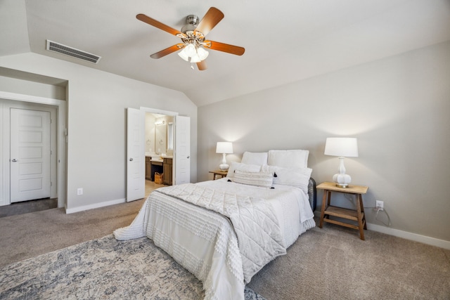 bedroom with ceiling fan, ensuite bathroom, vaulted ceiling, and carpet