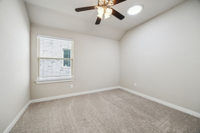 empty room featuring ceiling fan, lofted ceiling, and carpet flooring