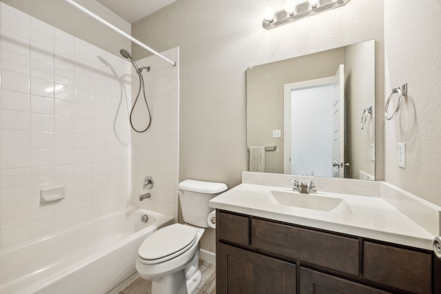 full bathroom featuring vanity, tiled shower / bath combo, and toilet