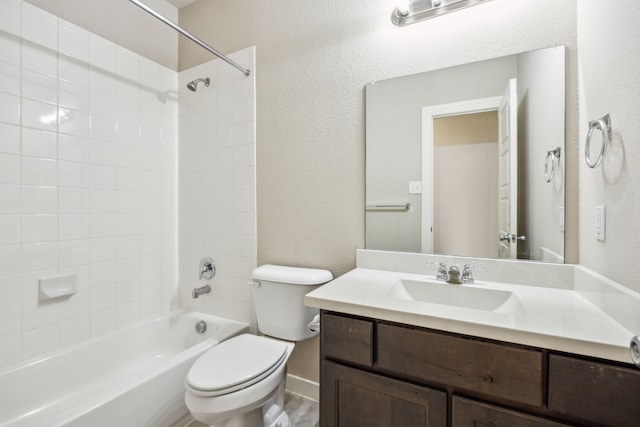 full bathroom featuring vanity, tiled shower / bath combo, and toilet