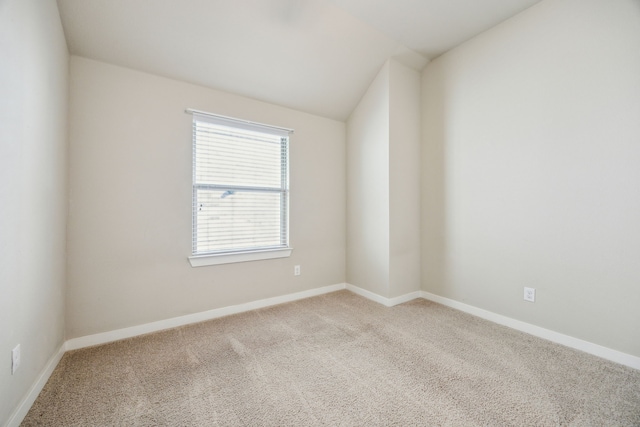 empty room featuring lofted ceiling and light carpet