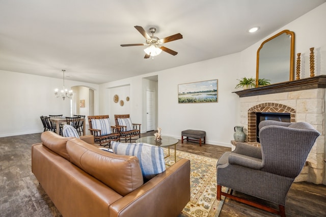 living room with dark wood-type flooring and ceiling fan with notable chandelier