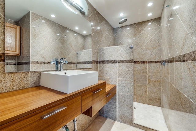 bathroom featuring walk in shower, sink, and tile walls