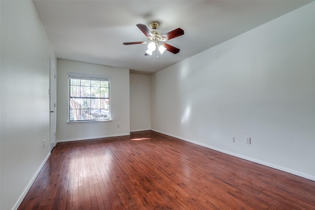 spare room with ceiling fan, baseboards, and dark wood finished floors