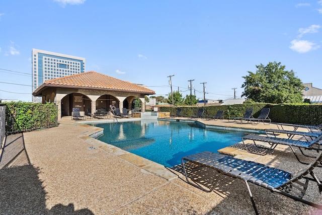 pool with an outbuilding, fence, and a patio