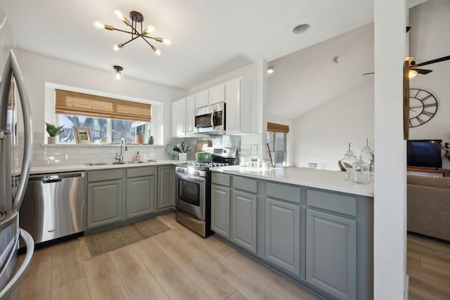 kitchen featuring sink, white cabinetry, appliances with stainless steel finishes, gray cabinets, and light hardwood / wood-style floors