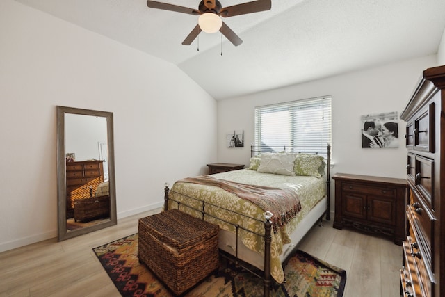 bedroom featuring ceiling fan, lofted ceiling, and light wood-type flooring