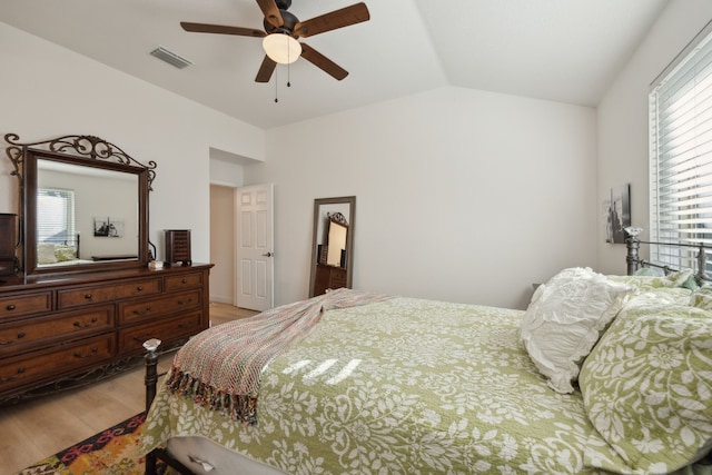 bedroom with hardwood / wood-style flooring, ceiling fan, vaulted ceiling, and multiple windows