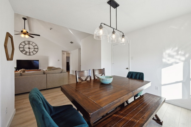 dining area with light hardwood / wood-style flooring, ceiling fan, and vaulted ceiling