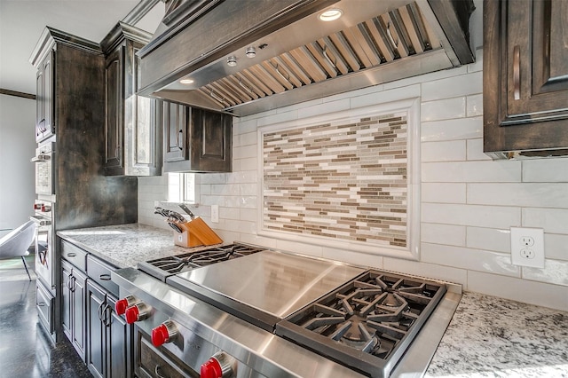 kitchen featuring decorative backsplash, dark brown cabinets, and custom range hood