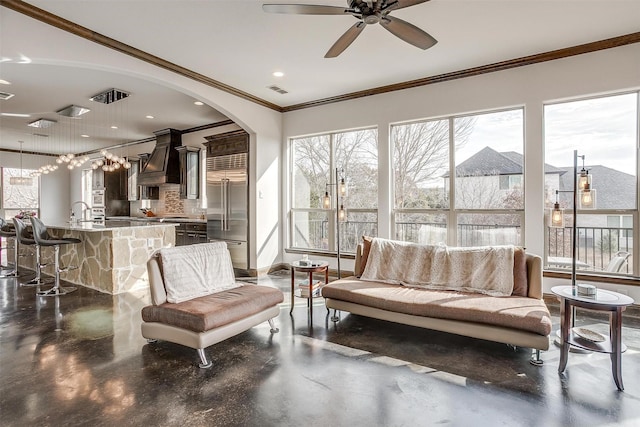 living room with ceiling fan and ornamental molding