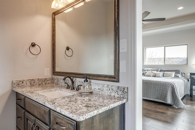 bathroom with wood-type flooring, vanity, and ceiling fan