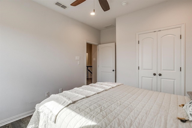 bedroom featuring dark wood-type flooring, a closet, and ceiling fan