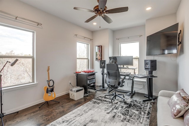 office area featuring ceiling fan, dark wood-type flooring, and a healthy amount of sunlight