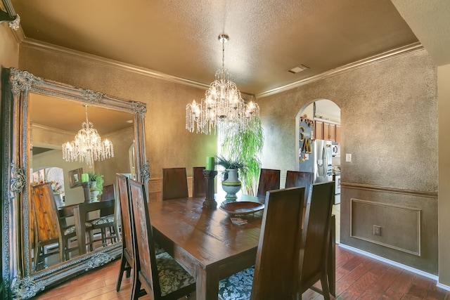 dining room with ornamental molding, hardwood / wood-style floors, and a notable chandelier