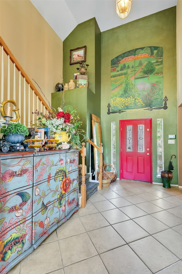 tiled entryway featuring high vaulted ceiling