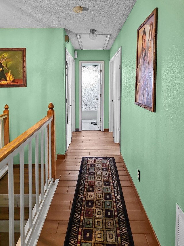 corridor featuring wood-type flooring and a textured ceiling