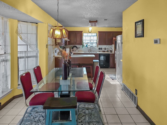 tiled dining room with sink and a textured ceiling