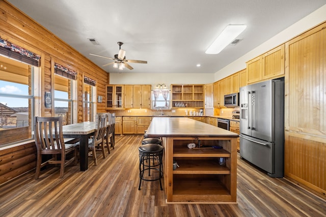 kitchen featuring dark hardwood / wood-style flooring, sink, a kitchen island, and appliances with stainless steel finishes