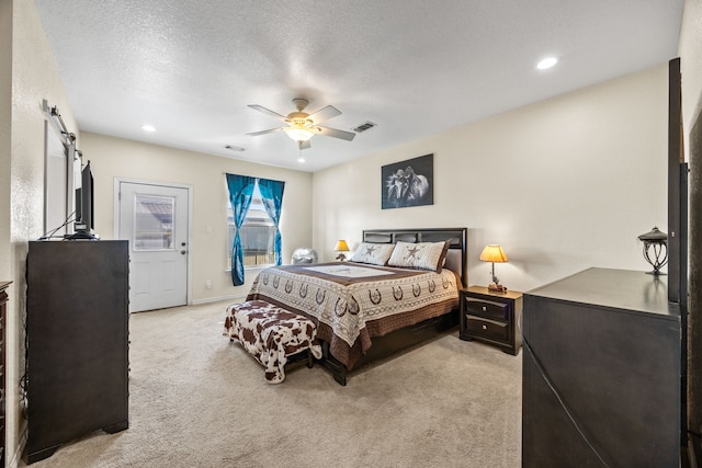 bedroom with ceiling fan, access to exterior, a textured ceiling, light carpet, and a barn door