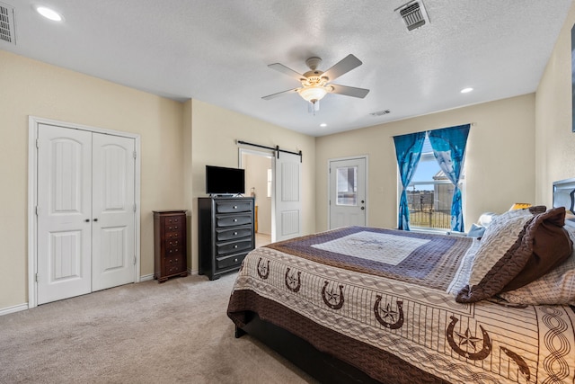 bedroom featuring access to exterior, ceiling fan, a barn door, light carpet, and a textured ceiling