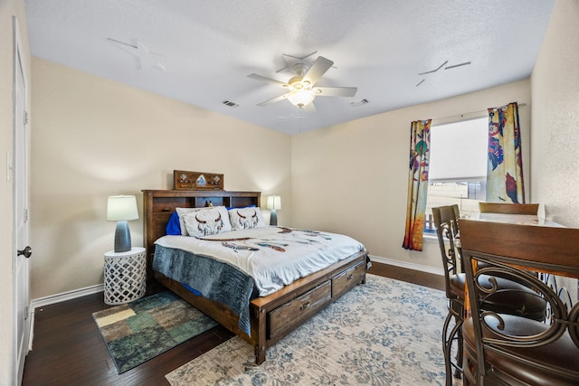 bedroom with ceiling fan, dark hardwood / wood-style flooring, and a textured ceiling