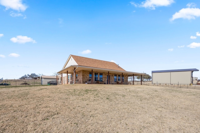 rear view of property with an outbuilding and a lawn