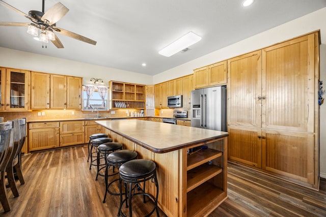 kitchen featuring a kitchen bar, a kitchen island, dark hardwood / wood-style floors, and appliances with stainless steel finishes