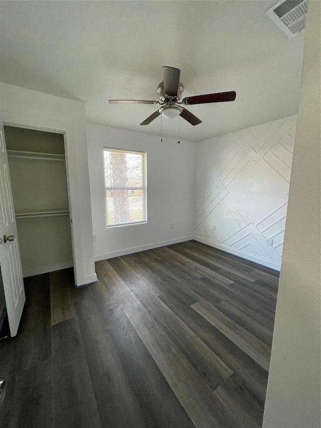 unfurnished bedroom with ceiling fan, dark hardwood / wood-style flooring, and a closet