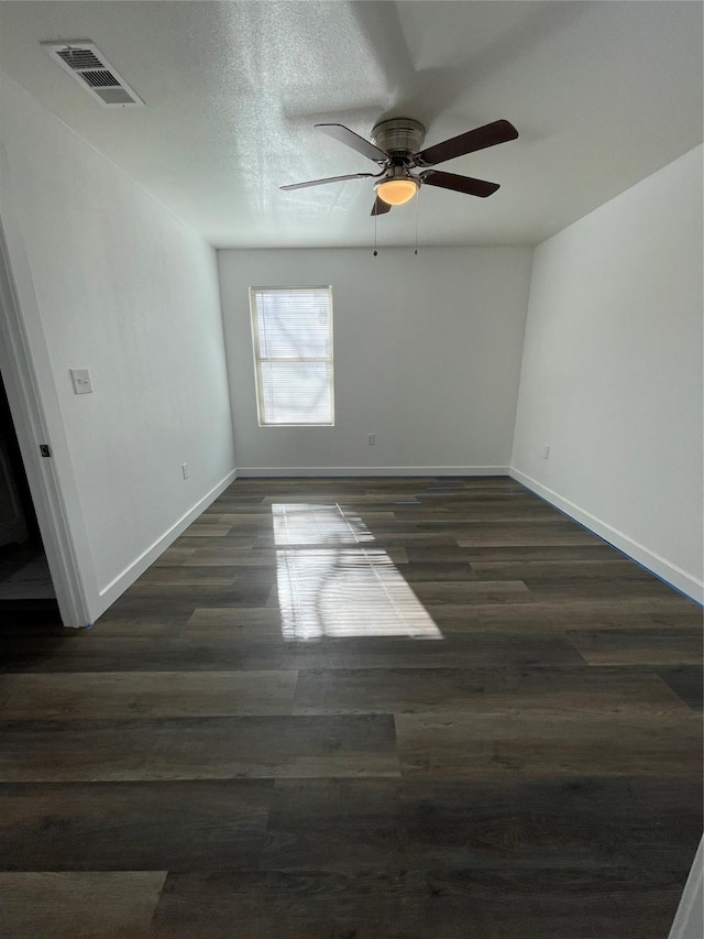 spare room with dark wood-type flooring, ceiling fan, and a textured ceiling