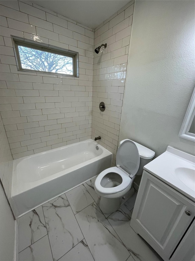 full bathroom with tiled shower / bath, vanity, and toilet