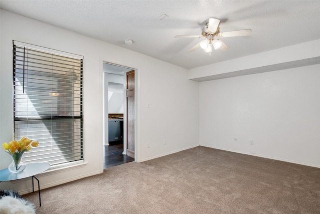 interior space featuring a textured ceiling, ceiling fan, and dark colored carpet