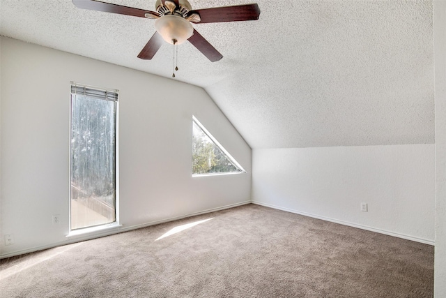 bonus room with ceiling fan, carpet flooring, vaulted ceiling, and a textured ceiling