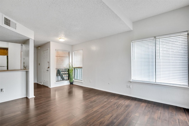 unfurnished living room with dark hardwood / wood-style floors and a textured ceiling