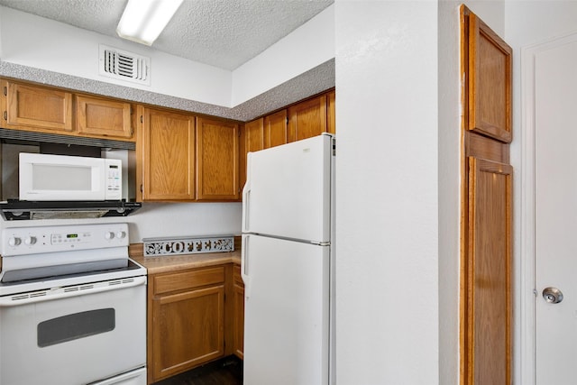 kitchen featuring white appliances and a textured ceiling