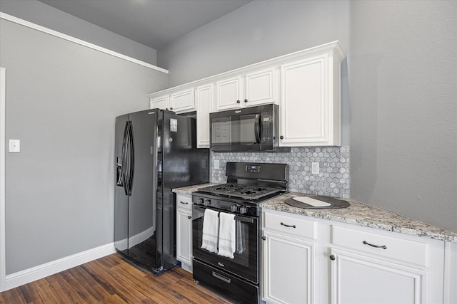 kitchen featuring tasteful backsplash, white cabinets, dark hardwood / wood-style flooring, light stone counters, and black appliances