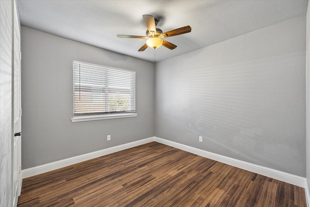 empty room featuring dark wood-type flooring and ceiling fan