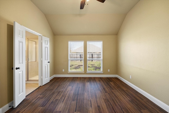 empty room with vaulted ceiling, dark hardwood / wood-style floors, and ceiling fan