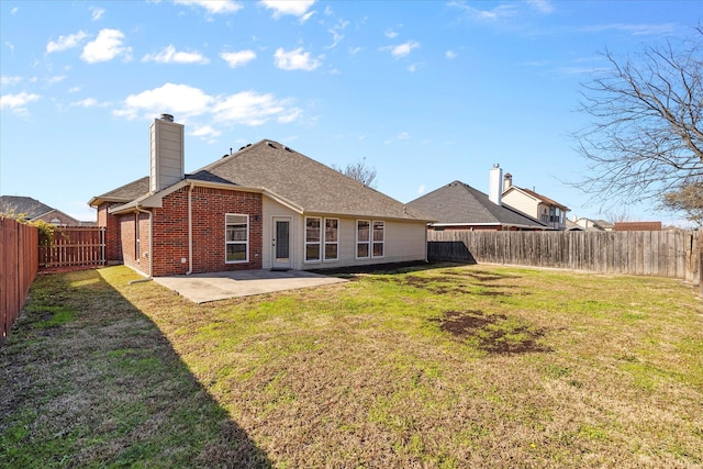 rear view of property featuring a yard and a patio area