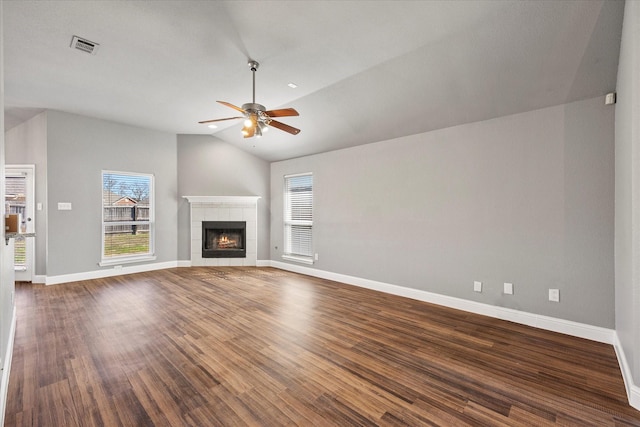 unfurnished living room featuring a tiled fireplace, wood-type flooring, vaulted ceiling, and ceiling fan