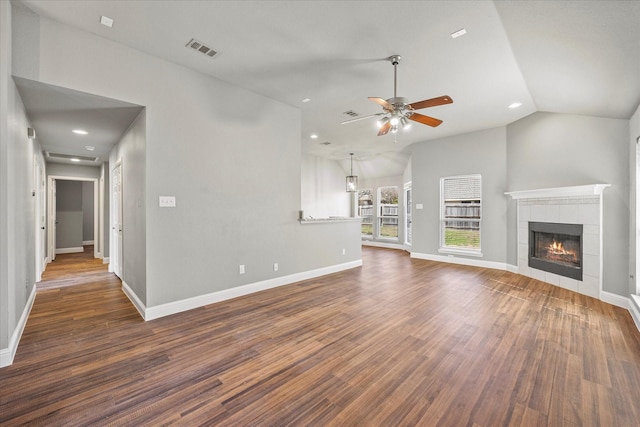 unfurnished living room featuring vaulted ceiling, dark hardwood / wood-style floors, ceiling fan, and a fireplace