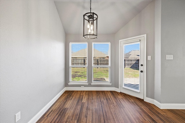 unfurnished dining area with lofted ceiling, dark hardwood / wood-style flooring, a chandelier, and a wealth of natural light