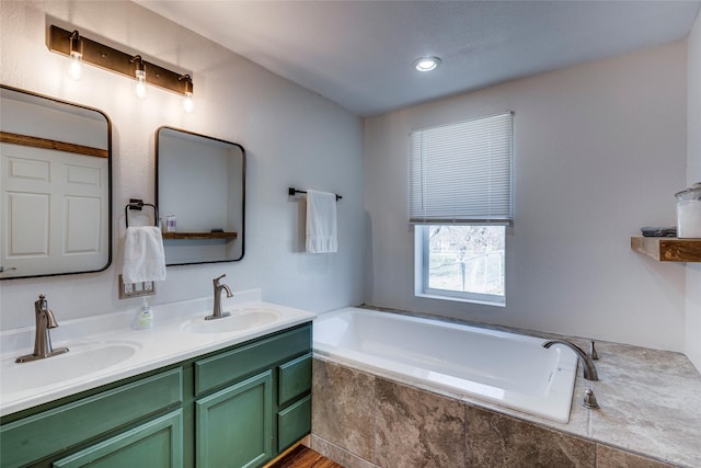 bathroom featuring a relaxing tiled tub and vanity