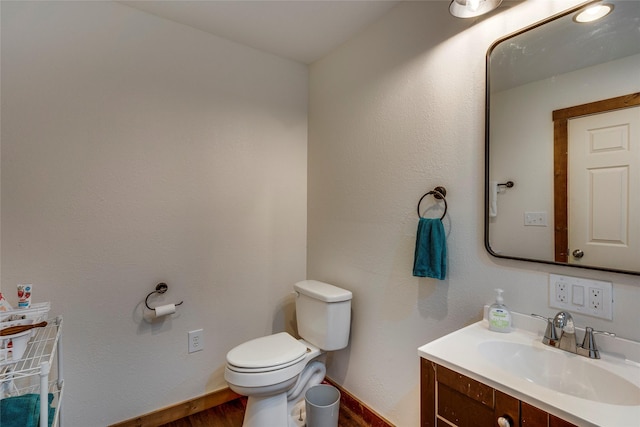 bathroom with vanity, wood-type flooring, and toilet