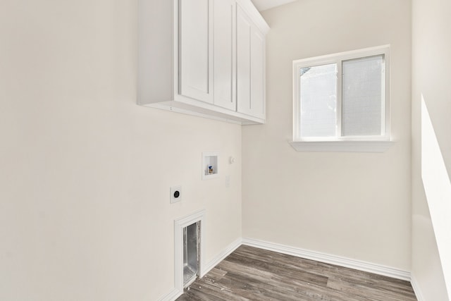 laundry area with electric dryer hookup, hookup for a washing machine, dark wood-type flooring, and cabinets