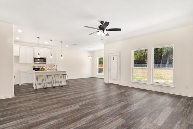 unfurnished living room with dark wood-type flooring and ceiling fan