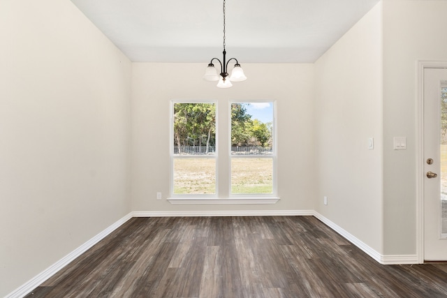 unfurnished dining area with dark hardwood / wood-style floors and a chandelier